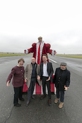 Hochformat: Hannes Heesch, etwas erhöht, als Donald Trump im Hermelin-Mantel. Er breitet die Arme aus. Vor ihm, etwas tiefer, stehen Christoph Jungmann, Bov Bjerg, Horst Evers und Manfred Maurenbrecher und schreien ihre Verzweiflung heraus.